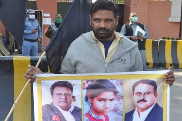Asif Masih sostiene una foto de su hija durante una protesta en Faisalabad