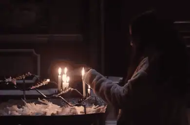 Joven encendiendo una vela en una iglesia de Irak