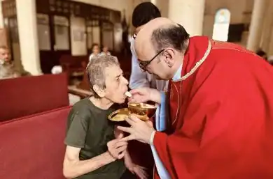 Niña recibiendo comunión durante una ceremonia religiosa cristiana en una iglesia.