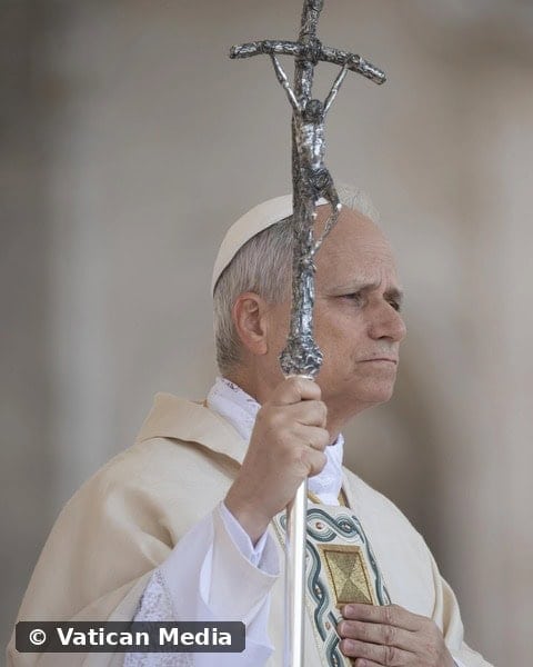 El papa León XIV sostiene la cruz papal, con la mano sobre el corazón, en oración